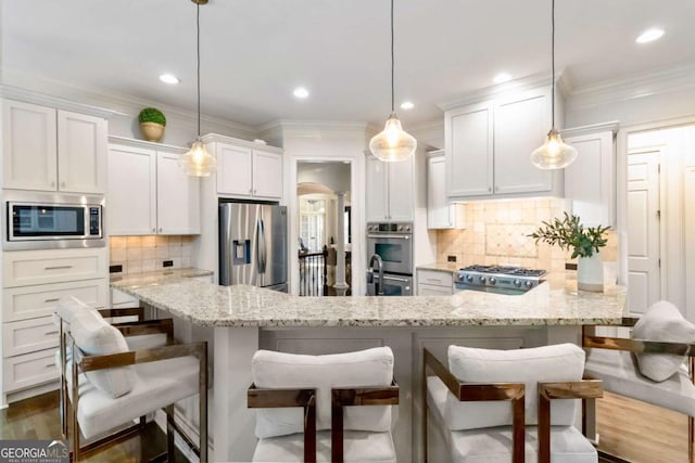 2230 Cambridge Hill Ct, Dacula, GA 30019 - kitchen with stainless steel appliances, white cabinetry, decorative backsplash, crown molding, and a breakfast bar
