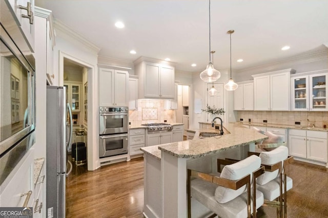 2230 Cambridge Hill Ct, Dacula, GA 30019 - kitchen featuring appliances with stainless steel finishes, decorative backsplash, a breakfast bar area, white cabinetry, and recessed lighting