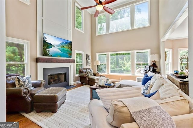 121 Fairway Overlook, Woodstock, GA 30188 - living room with a towering ceiling, wood finished floors, ceiling fan, a fireplace, and ornamental molding