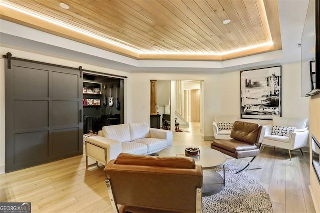 121 Fairway Overlook, Woodstock, GA 30188 - living area featuring a tray ceiling, a barn door, wood ceiling, and light wood-style flooring