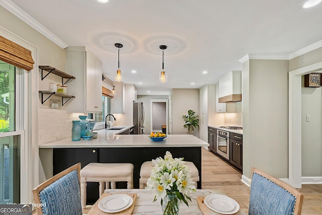 115 Edgewater Way, Peachtree City, GA 30269 - kitchen with stainless steel appliances, open shelves, tasteful backsplash, light wood-style floors, and crown molding