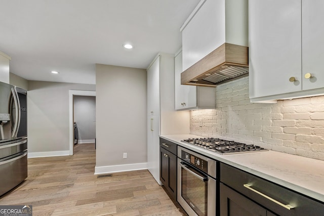 115 Edgewater Way, Peachtree City, GA 30269 - kitchen with appliances with stainless steel finishes, custom exhaust hood, light countertops, light wood-type flooring, and recessed lighting