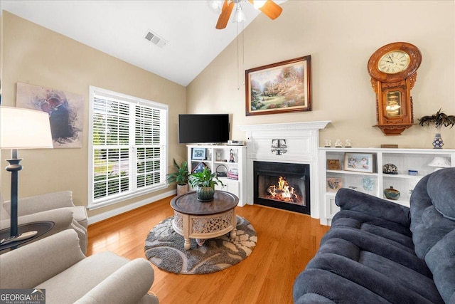221 Timber Ridge Dr, Clarkesville, GA 30523 - living area featuring wood finished floors, ceiling fan, a warm lit fireplace, and high vaulted ceiling