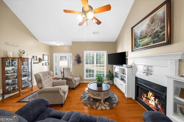 221 Timber Ridge Dr, Clarkesville, GA 30523 - living area with lofted ceiling, light wood-style floors, a glass covered fireplace, and a ceiling fan