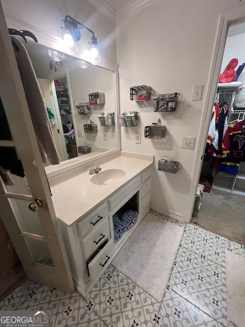 974 Bloomfield Dr, Lawrenceville, GA 30044 - bathroom featuring crown molding, vanity, and a walk in closet