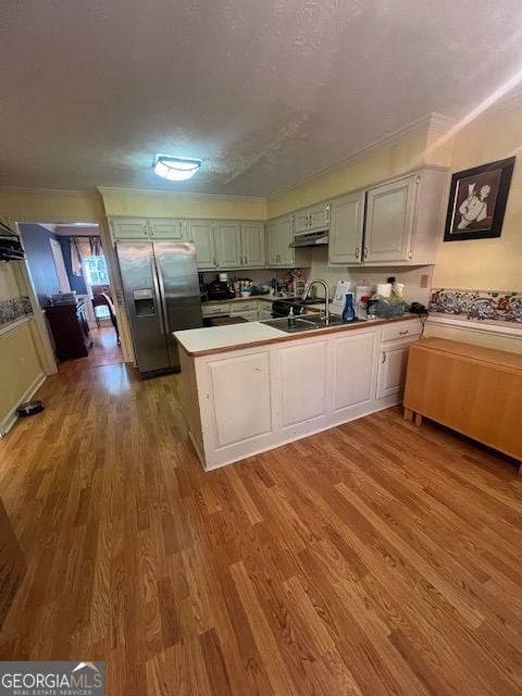 974 Bloomfield Dr, Lawrenceville, GA 30044 - kitchen featuring stainless steel refrigerator with ice dispenser, a peninsula, wood finished floors, crown molding, and under cabinet range hood