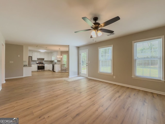 1904 Watercrest Cir, Lawrenceville, GA 30043 - unfurnished living room with ceiling fan, light wood-type flooring, and a chandelier