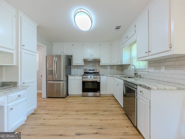 1904 Watercrest Cir, Lawrenceville, GA 30043 - kitchen featuring stainless steel appliances, under cabinet range hood, light stone counters, backsplash, and white cabinets