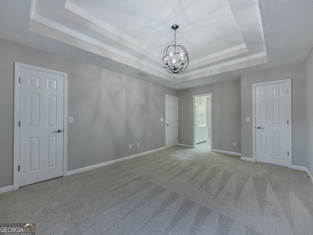 1904 Watercrest Cir, Lawrenceville, GA 30043 - unfurnished bedroom featuring a tray ceiling, a chandelier, carpet floors, ornamental molding, and ensuite bathroom