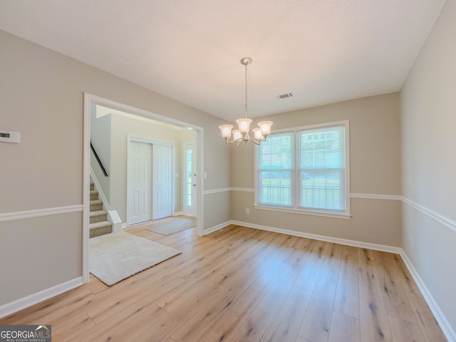 1904 Watercrest Cir, Lawrenceville, GA 30043 - unfurnished dining area featuring a chandelier, light wood-style floors, and stairs