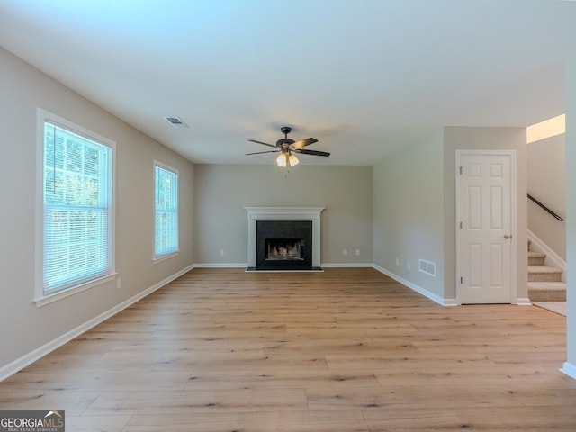 1904 Watercrest Cir, Lawrenceville, GA 30043 - unfurnished living room with ceiling fan, stairs, light wood-style floors, and a fireplace