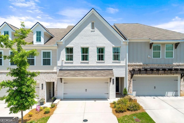 1316 Willamette Way, Marietta, GA 30008 - townhome / multi-family property featuring driveway, a garage, board and batten siding, and brick siding