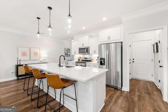 1316 Willamette Way, Marietta, GA 30008 - kitchen with stainless steel appliances, crown molding, a center island with sink, a breakfast bar, and white cabinetry