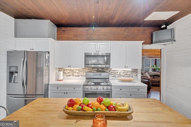 4253 Swallows Creek Rd, Hiawassee, GA 30546 - kitchen with stainless steel appliances, wood walls, wooden ceiling, butcher block countertops, and tasteful backsplash