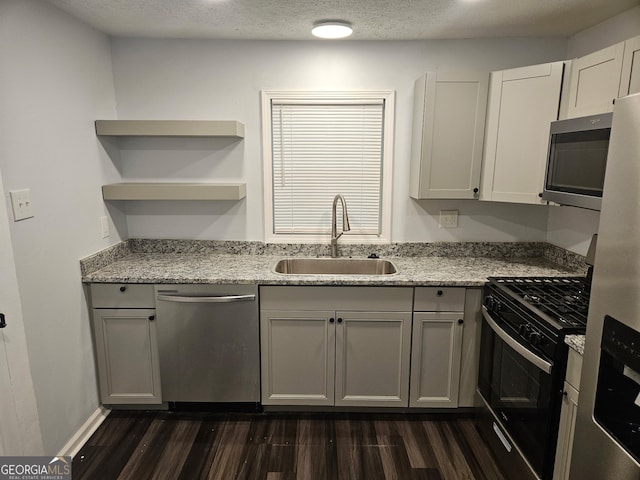 4422 Oates Ave, Columbus, GA 31904 - kitchen featuring appliances with stainless steel finishes, dark wood finished floors, light stone countertops, a textured ceiling, and open shelves
