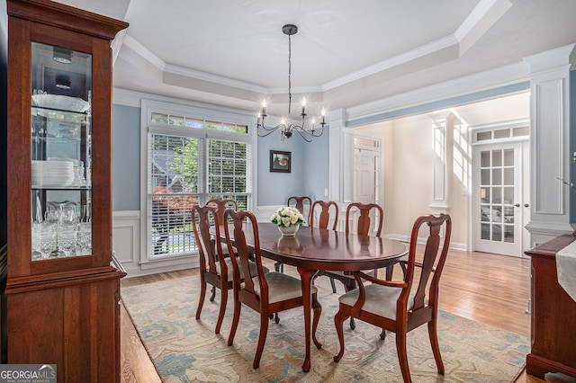 351 Prestbury Ct, Suwanee, GA 30024 - dining area with light wood finished floors, a chandelier, a raised ceiling, wainscoting, and crown molding