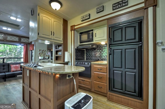 236 31st St Unit C638, Ellijay, GA 30540 - kitchen featuring black appliances, decorative backsplash, light wood-type flooring, and light countertops