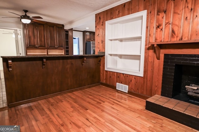 500 Holmes St, Barnesville, GA 30204 - kitchen featuring stainless steel fridge with ice dispenser, crown molding, a ceiling fan, a breakfast bar area, and light wood-style floors