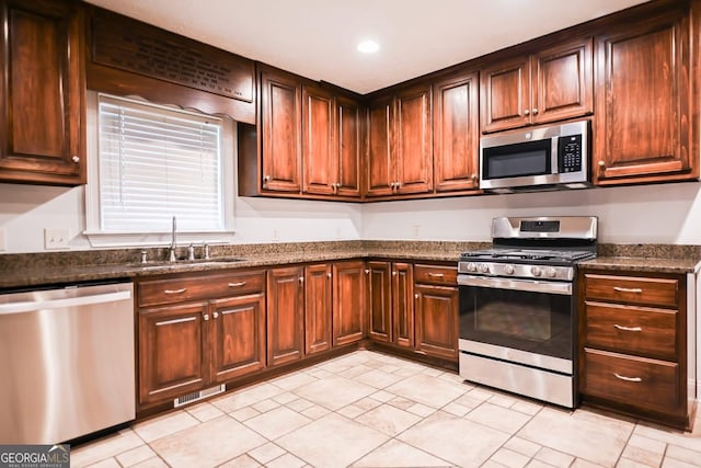 500 Holmes St, Barnesville, GA 30204 - kitchen with appliances with stainless steel finishes, recessed lighting, dark stone countertops, and light tile patterned floors