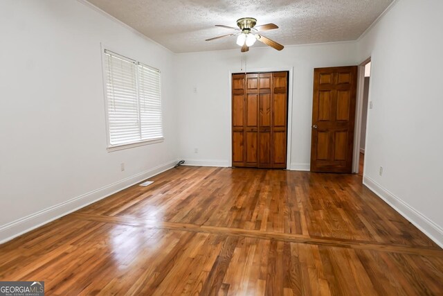 500 Holmes St, Barnesville, GA 30204 - unfurnished bedroom with a textured ceiling, wood finished floors, a closet, a ceiling fan, and crown molding