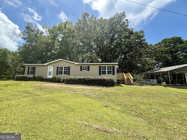 314 Elbert Jackson Rd, Forsyth, GA 31029 - manufactured / mobile home with a front lawn, a carport, stairway, and view of wooded area