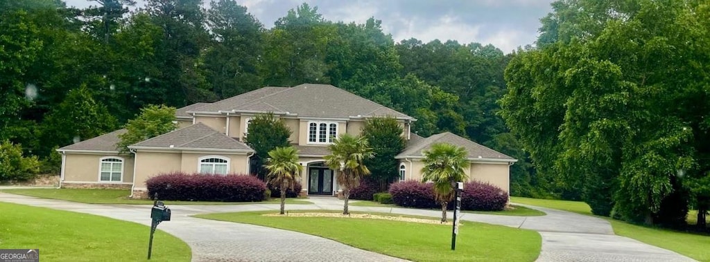 345 Peaceful Way, Fayetteville, GA 30214 - view of front facade featuring curved driveway, stucco siding, and a front lawn