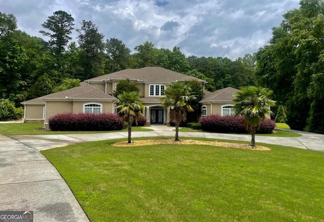 345 Peaceful Way, Fayetteville, GA 30214 - mediterranean / spanish house featuring curved driveway, french doors, a front lawn, and stucco siding