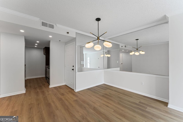1280 W Peachtree St NW Unit 808, Atlanta, GA 30309 - unfurnished dining area with a chandelier, a textured ceiling, ornamental molding, and wood finished floors