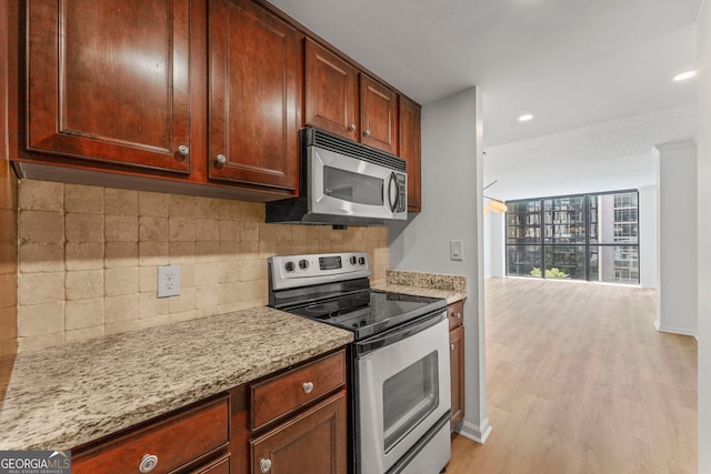 1280 W Peachtree St NW Unit 808, Atlanta, GA 30309 - kitchen featuring appliances with stainless steel finishes, decorative backsplash, light wood-style floors, light stone counters, and recessed lighting