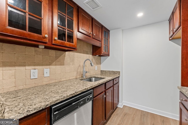 1280 W Peachtree St NW Unit 808, Atlanta, GA 30309 - kitchen featuring dishwasher, light wood-style flooring, light stone countertops, backsplash, and glass insert cabinets
