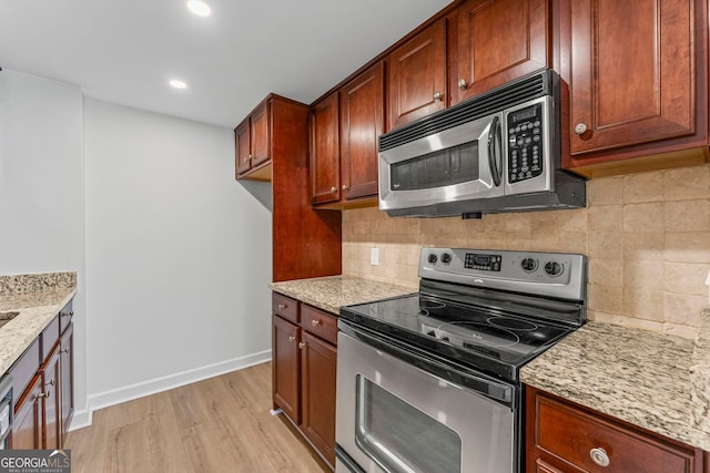 1280 W Peachtree St NW Unit 808, Atlanta, GA 30309 - kitchen featuring appliances with stainless steel finishes, light wood-style flooring, light stone counters, tasteful backsplash, and recessed lighting
