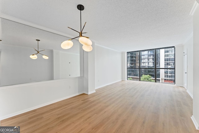 1280 W Peachtree St NW Unit 808, Atlanta, GA 30309 - unfurnished living room featuring a chandelier, wood finished floors, a textured ceiling, and ornamental molding