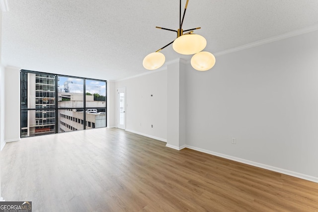 1280 W Peachtree St NW Unit 808, Atlanta, GA 30309 - unfurnished room featuring a textured ceiling, wood finished floors, crown molding, and a wall of windows