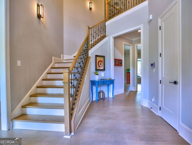 913 Sunny Meadows Ln, Marietta, GA 30062 - stairs featuring wood finished floors, a towering ceiling, and crown molding