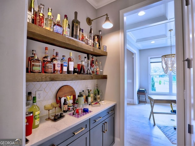 913 Sunny Meadows Ln, Marietta, GA 30062 - indoor dry bar featuring backsplash, light wood-style floors, crown molding, coffered ceiling, and a chandelier