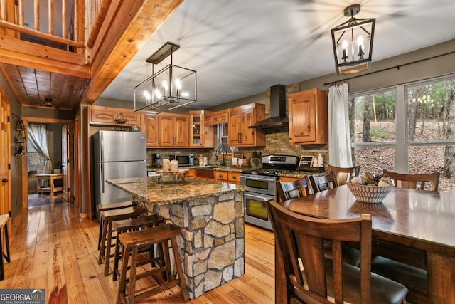 230 Grove Ln Unit 3642, Ellijay, GA 30540 - kitchen featuring wall chimney exhaust hood, stainless steel appliances, a chandelier, and light wood-type flooring