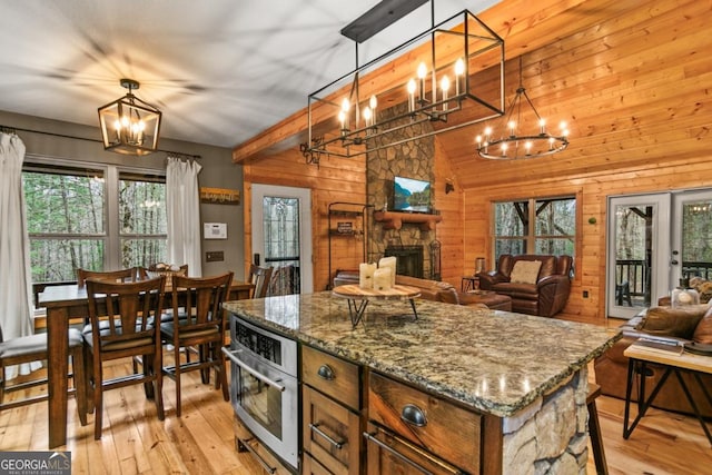 230 Grove Ln Unit 3642, Ellijay, GA 30540 - kitchen featuring a chandelier, wooden walls, stainless steel oven, vaulted ceiling, and light wood finished floors