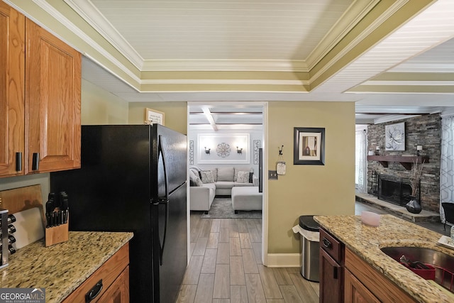 1313 Old Countryside Cir, Stone Mountain, GA 30083 - kitchen featuring freestanding refrigerator, wood tiled floors, brown cabinetry, light stone counters, and a tray ceiling