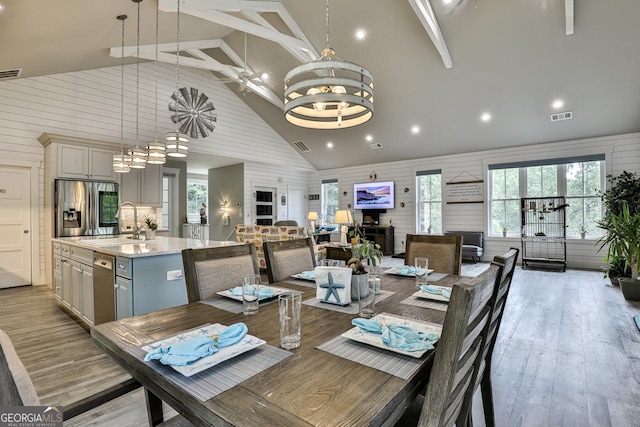 682 Tanglewood Ln, Ellijay, GA 30540 - dining space with a chandelier, light wood-type flooring, high vaulted ceiling, and wooden walls