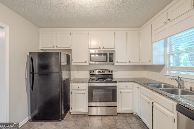 3110 Ashly Cove Ln, Snellville, GA 30078 - kitchen featuring stainless steel appliances, white cabinetry, tasteful backsplash, and a textured ceiling
