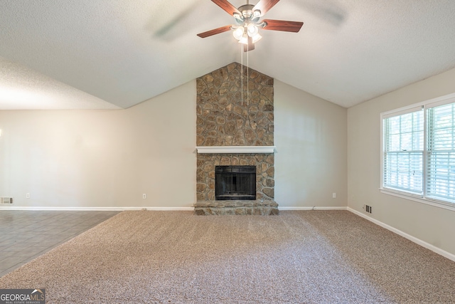 3110 Ashly Cove Ln, Snellville, GA 30078 - unfurnished living room featuring ceiling fan, a textured ceiling, lofted ceiling, and a stone fireplace