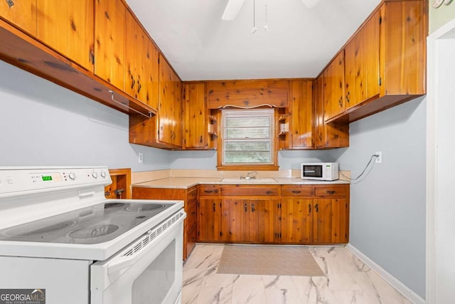 135 5th Ave, Jonesboro, GA 30236 - kitchen with white appliances, light marble finish floors, light countertops, and brown cabinets