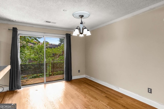 115 Biscayne Dr NW Unit E3, Atlanta, GA 30309 - unfurnished room with a chandelier, ornamental molding, a textured ceiling, and light wood-type flooring