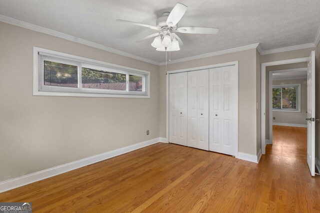 115 Biscayne Dr NW Unit E3, Atlanta, GA 30309 - unfurnished bedroom with multiple windows, a closet, light wood-style floors, a ceiling fan, and ornamental molding