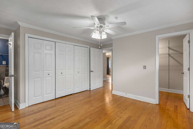 115 Biscayne Dr NW Unit E3, Atlanta, GA 30309 - unfurnished bedroom featuring light wood finished floors, a closet, connected bathroom, a ceiling fan, and crown molding