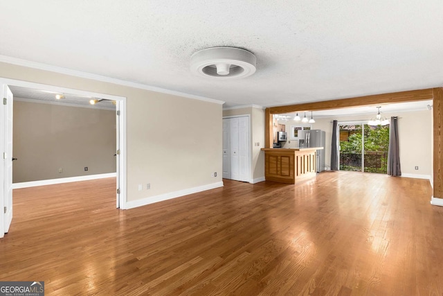 115 Biscayne Dr NW Unit E3, Atlanta, GA 30309 - unfurnished living room featuring wood finished floors, crown molding, a chandelier, and a textured ceiling