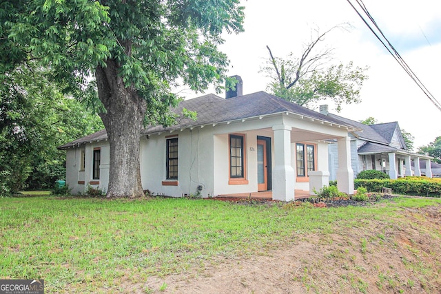 826 W Grenada Ter, Macon, GA 31206 - view of front of house with a porch, a front yard, stucco siding, and a chimney
