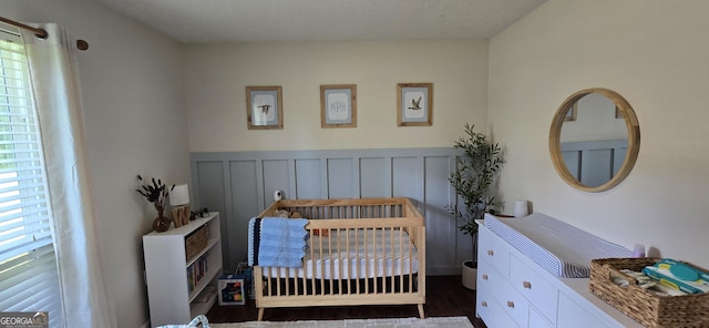 467 Witherington Cir, East Dublin, GA 31027 - bedroom with a crib and a wainscoted wall