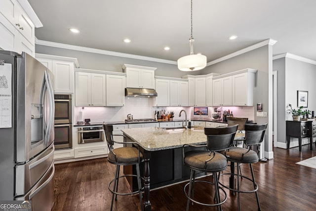 2470 Green Mountain Dr, Braselton, GA 30517 - kitchen with appliances with stainless steel finishes, under cabinet range hood, tasteful backsplash, white cabinetry, and recessed lighting
