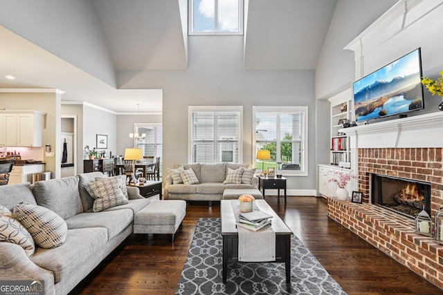 2470 Green Mountain Dr, Braselton, GA 30517 - living room featuring high vaulted ceiling, dark wood-style floors, plenty of natural light, a brick fireplace, and a chandelier